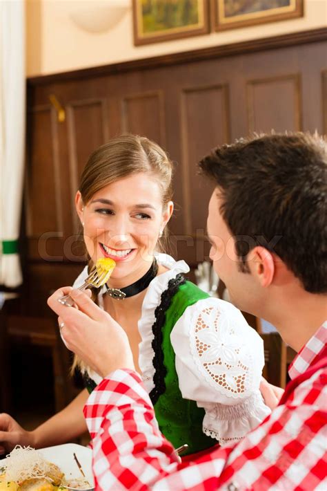 People In Traditional Bavarian Tracht Eating In Restaurant Or Pub