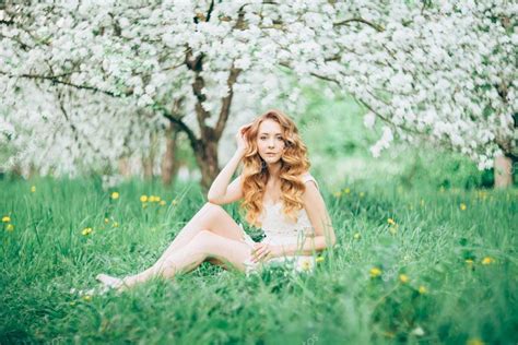 Симпатичная голая девушка в цветущем саду