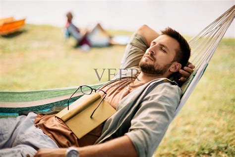 放松的男人在吊床上打盹，在大自然中度过一天。照片摄影图片id409404748 Veer图库