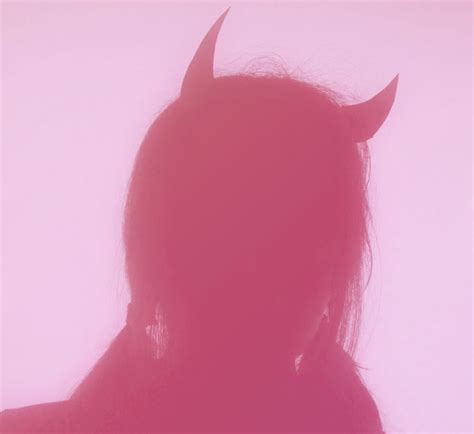 The Silhouette Of A Woman With Horns On Her Head Is Shown Against A