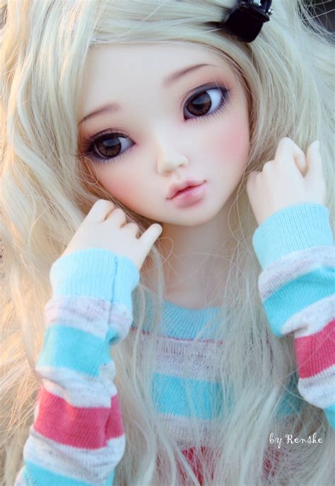 A Close Up Of A Doll With Long Blonde Hair And Blue Eyes Wearing A