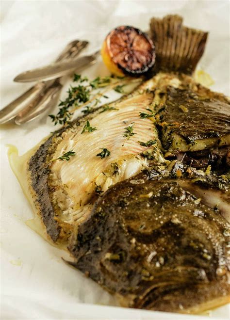 A Close Up Of A Fish On A Plate With Utensils And A Fork