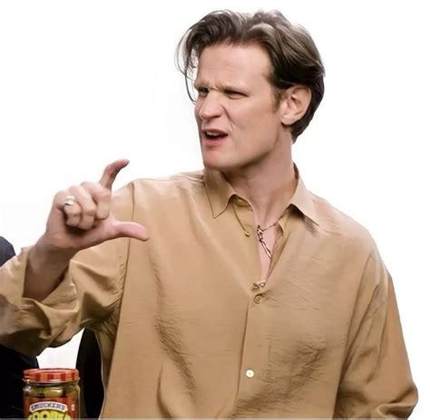 A Man In A Brown Shirt Pointing At Something With His Finger And Holding A Jar
