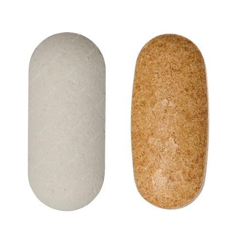 Premium Photo | White and brown oval tablets on isolated background