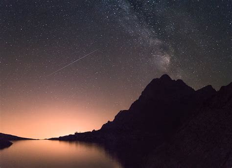 Body Of Water Near Mountains Under Starry Night · Free Stock Photo