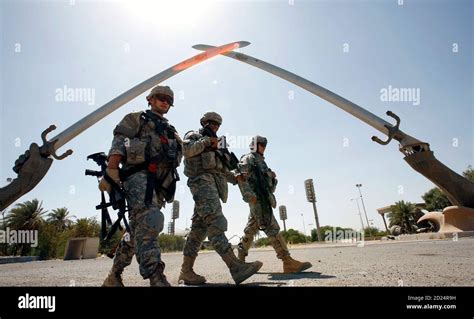 Us Soldiers Walks By The Swords Of Qadisiyah Monument In The Green