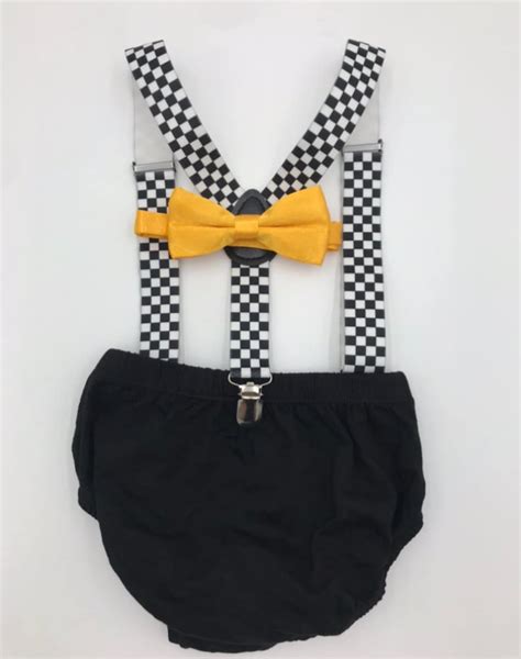 A Black And White Checkered Suspender With Yellow Bow Tie On The Chest