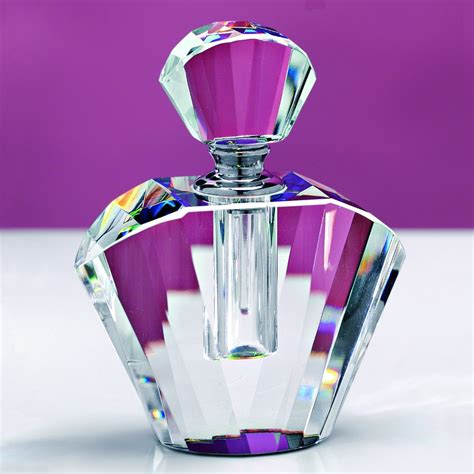 A Purple And Clear Perfume Bottle Sitting On Top Of A Table