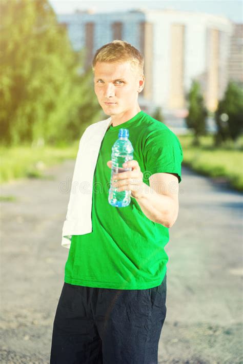 Tired Man With White Towel Drinking Water From A Plastic Bottle Stock