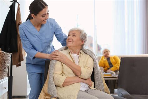 Nurse Taking Care Of Elderly Woman In Geriatric Hospice Stock Photo