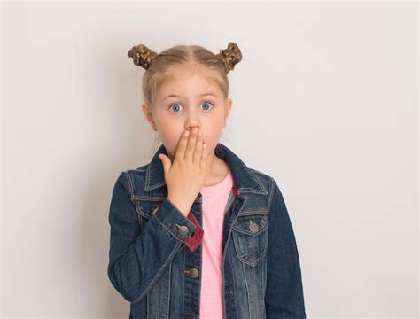 Premium Photo Little Surprised Girl Covering Mouth With Her Hand