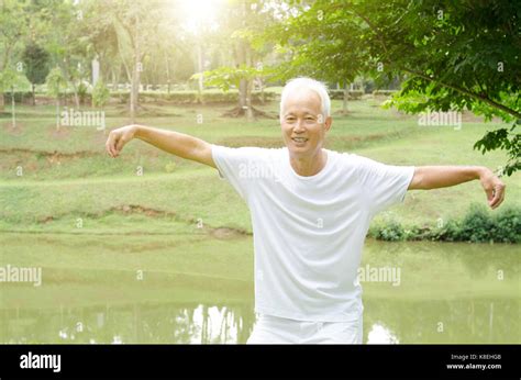 Portrait Of Healthy White Hair Asian Senior Man Practicing Qigong At Outdoor Park In Morning