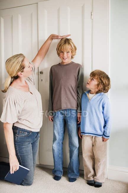 Mother Measuring Her Sons At Home — Boy High Stock Photo 169015482