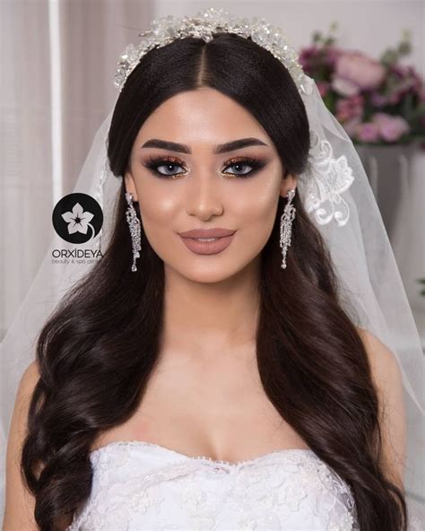 A Woman With Long Hair Wearing A Bridal Veil And Diamond Earring On Her