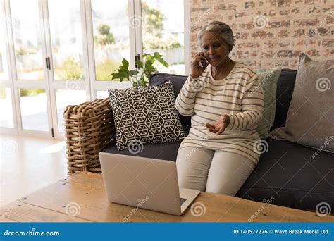 Senior Woman Talking On Mobile Phone In Living Room Stock Photo Image