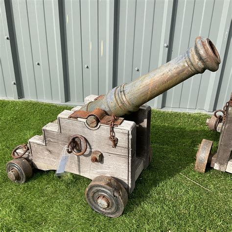 Pair of wood frame, cast iron barrel garden cannons on metal wheels