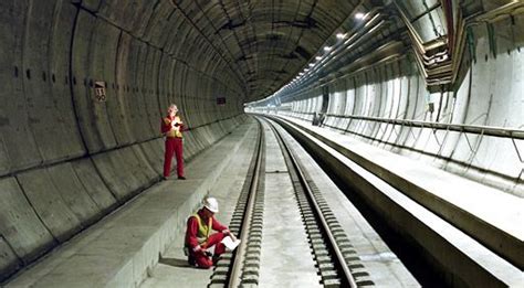 Two People Standing In A Tunnel Looking At Something On The Ground Next