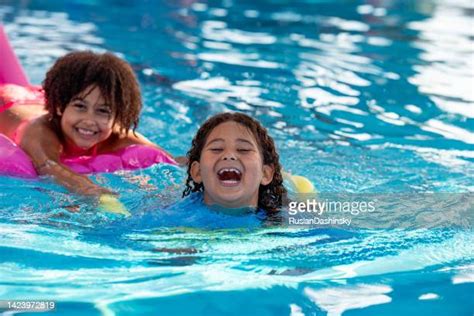 Little Girl Lying On Airbed Floating In Swimming Pool Photos And