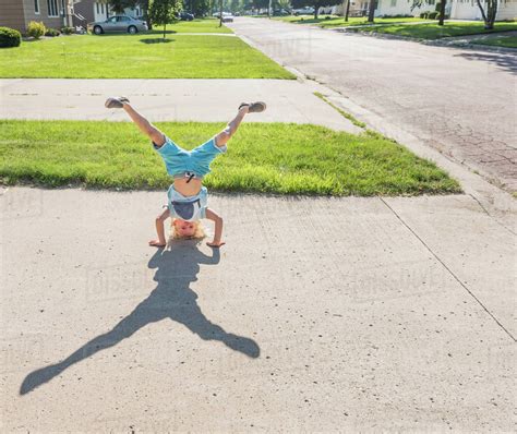 Boy Doing Handstand On Driveway Stock Photo Dissolve