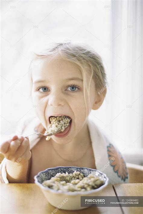 Girl Eating Breakfast From A Bowl — Mouth Open Home Interior Stock