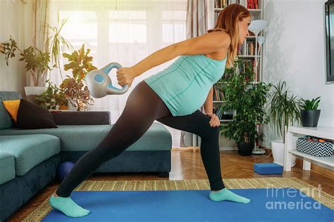 Pregnant Woman Exercising At Home Photograph By Microgen Imagesscience