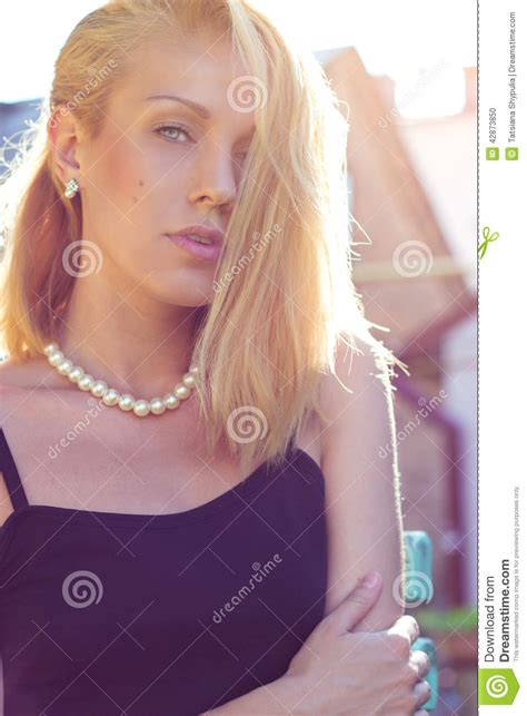 Portret Van Een Mooi Blondemeisje Met Blauwe Ogen Tegen De Muur Op De Straten Van De Stad Op Een