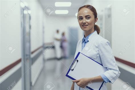 Focus On Serene Physician Standing In Hospital Corridor She Is Wearing