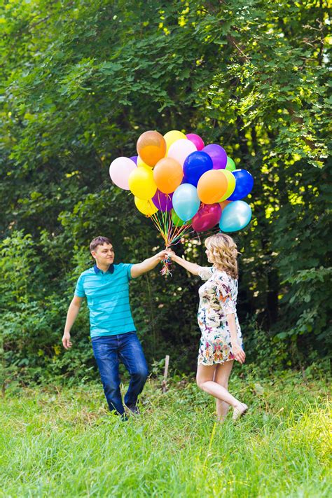 Premium Photo Man And His Pregnant Wife With Balloons Outdoors
