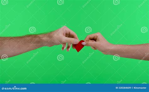 the couple breaks a small red paper heart close up of woman and man hands tearing love symbol