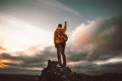 Premium Photo Successful Hiker Hiking A Mountain Pointing To The Sunset