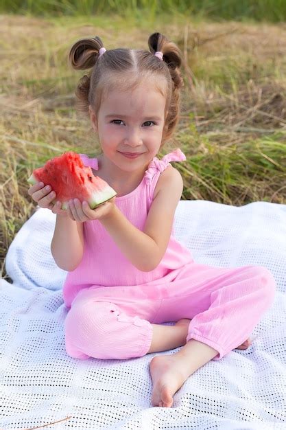 Premium Photo Cute Little Girl Eating Watermelon On The Grass In
