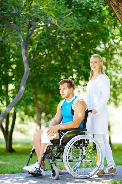 Free Photo Caregiver Pushing A Young Patient In Wheelchair Outdoors