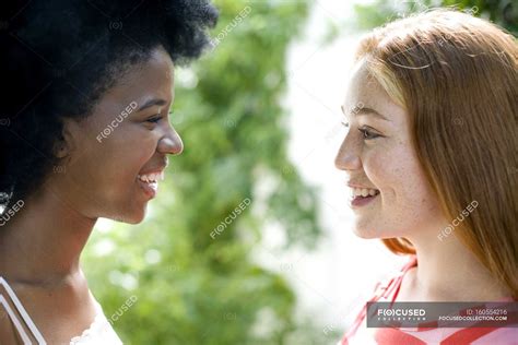 Two Teenage Girls Talking To Each Other Outdoors — Elation