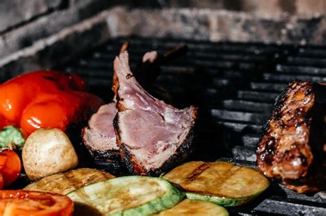 Мясо баранины на гриле. бараньи ребрышки на борту с овощами гриль. меню ...