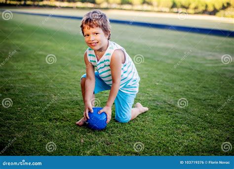 Happy Boy Playing With Ball And Toys On Green Grass Stock Photo Image