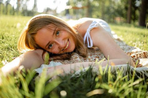 Pretty Blonde Woman Relaxing On The Grass In The Summer Park Stock