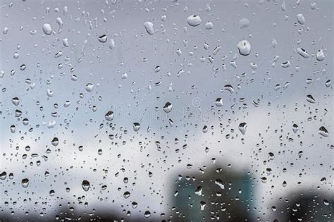 Rain Drops On Window Glasses Surface With Blue Sky Buildings And