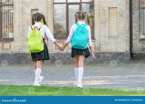 Back View Of Two Schoolgirls With School Backpack Walking Together Outdoor Friendship Stock