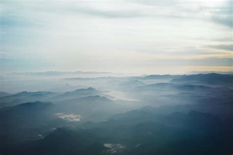 Aerial Photography Of Blue Mountains Surrounded By Fogs Under White Sky