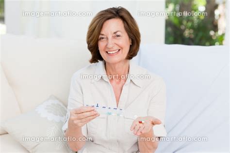 cute mature woman with pillsの写真素材 [31496042] イメージマート