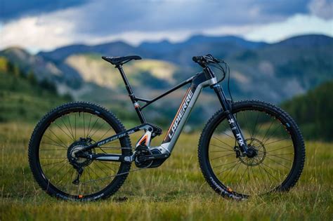 A Mountain Bike Parked In The Grass With Mountains In The Background