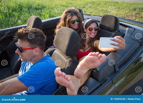 Two Beautiful Young Women Taking A Selfie In The Backseat Of A