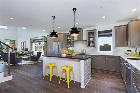 White kitchen interior with a wooden floor, a white bar stand, a row of white and gray stools, a laptop and consoles on. Gray Kitchen with Yellow Stools - Contemporary - Kitchen