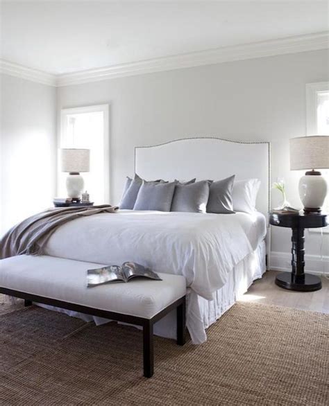 In this airy bedroom, white covers the floors, walls, and ceiling, but a charcoal bed skirt and dark wood furniture help ground the decor. bedrooms - silver gray paint white camelback headboard ...