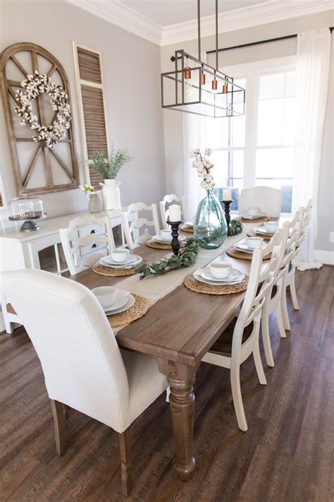 The Dining Room Table Is Set With White Chairs And Place Settings For