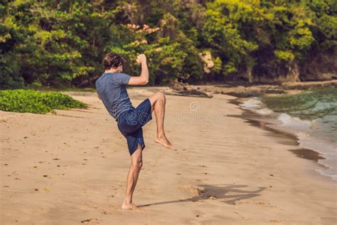 Young Male Working Out On Beach Sporty Man Doing Exercises Stock Photo