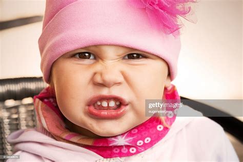 Closeup Portrait Of Funny Angry Baby Girl In Pink High Res Stock Photo