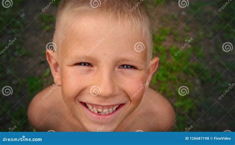 Close Up Portrait Of A Blue Eyed Little Boy Looking And Smiling