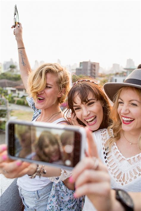 Three Smiling Girlfriends Take A Selfie On A Rooftop By Stocksy Contributor Jovo Jovanovic