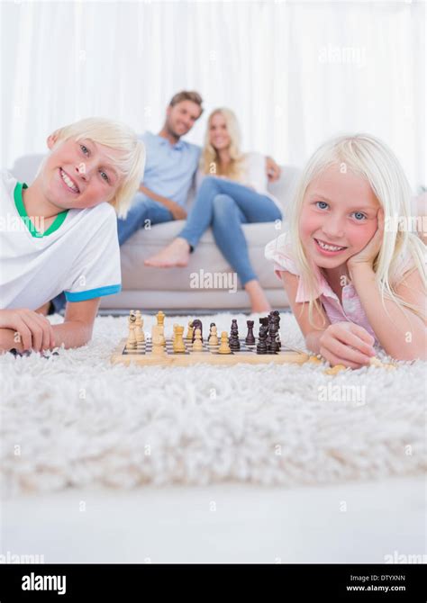 Children Lying On Carpet Playing Chess Stock Photo Alamy